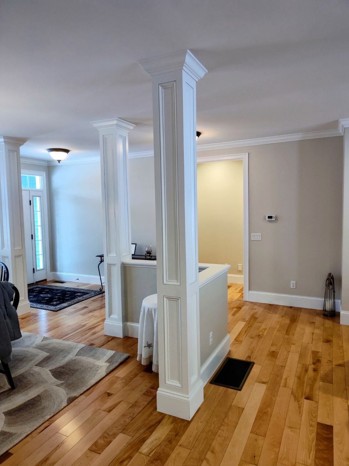 A living room with hardwood floors and white columns