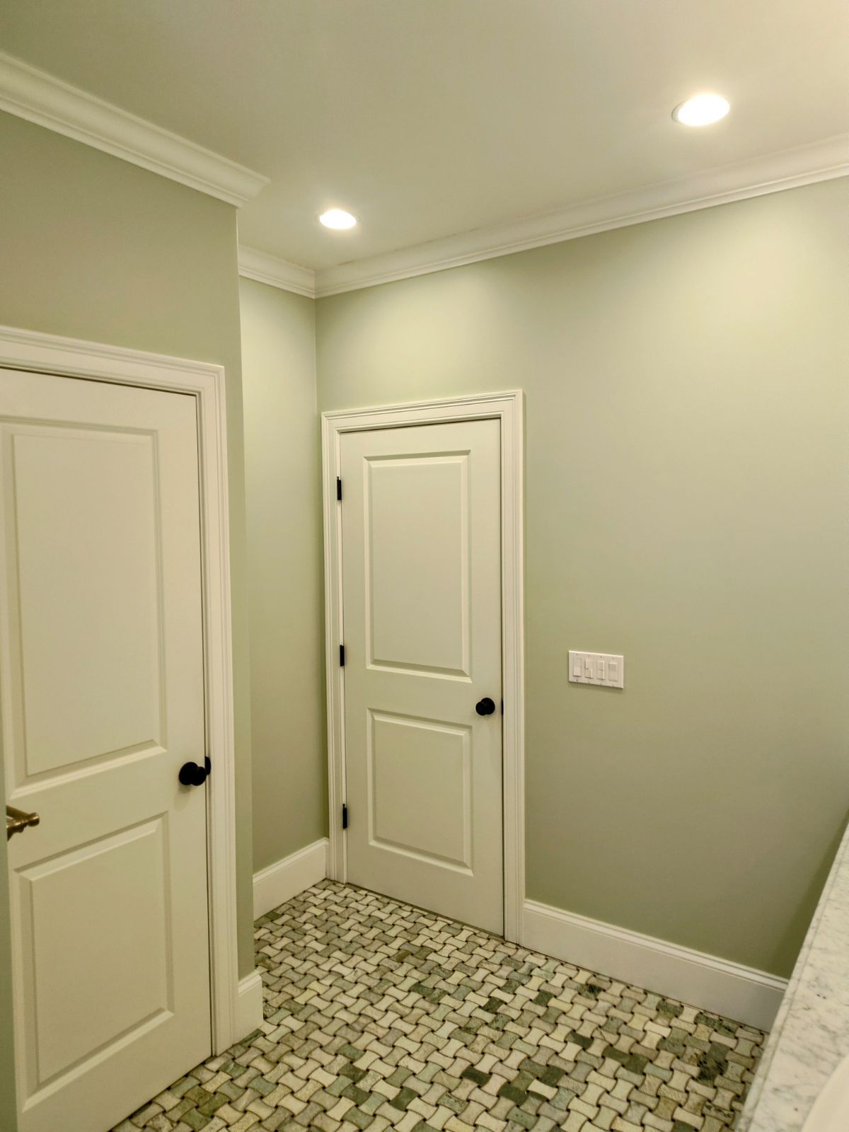 A hallway with two white doors
