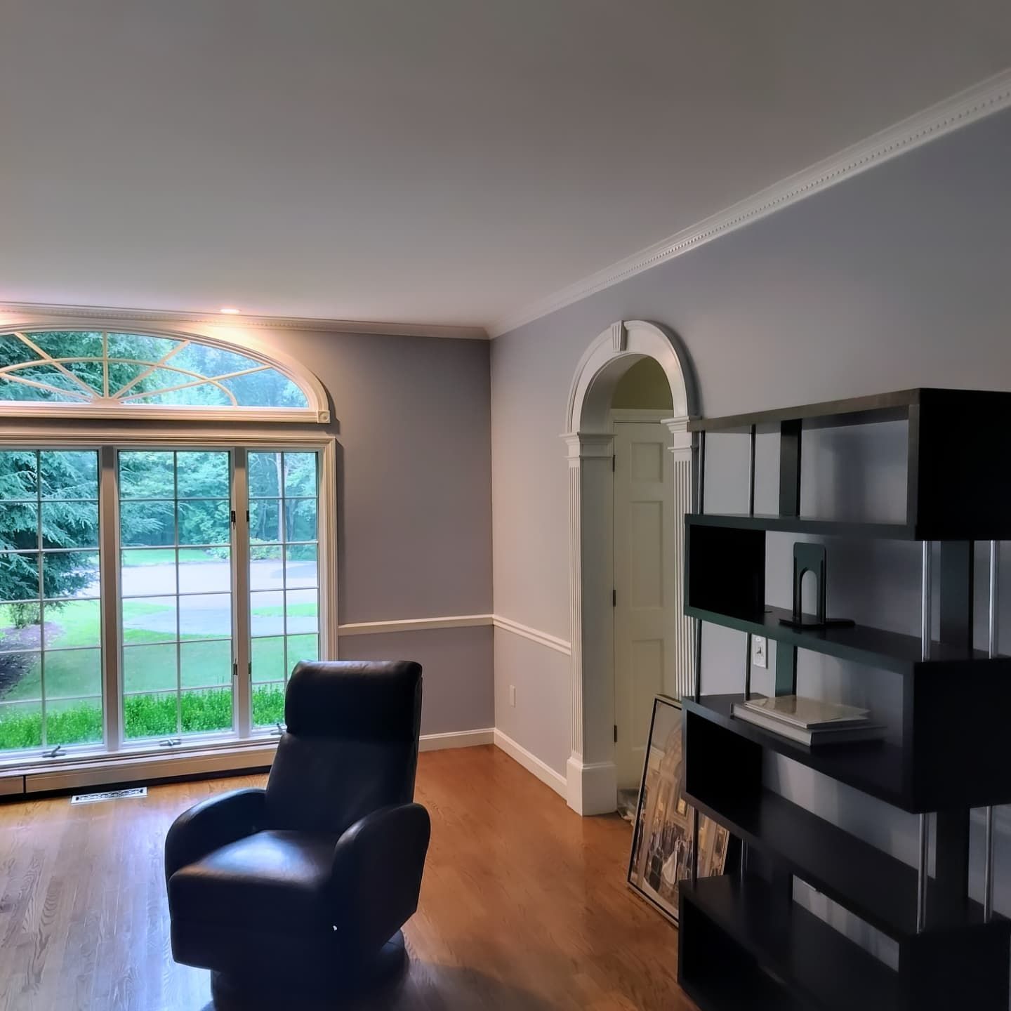 A living room with a large window and a chair