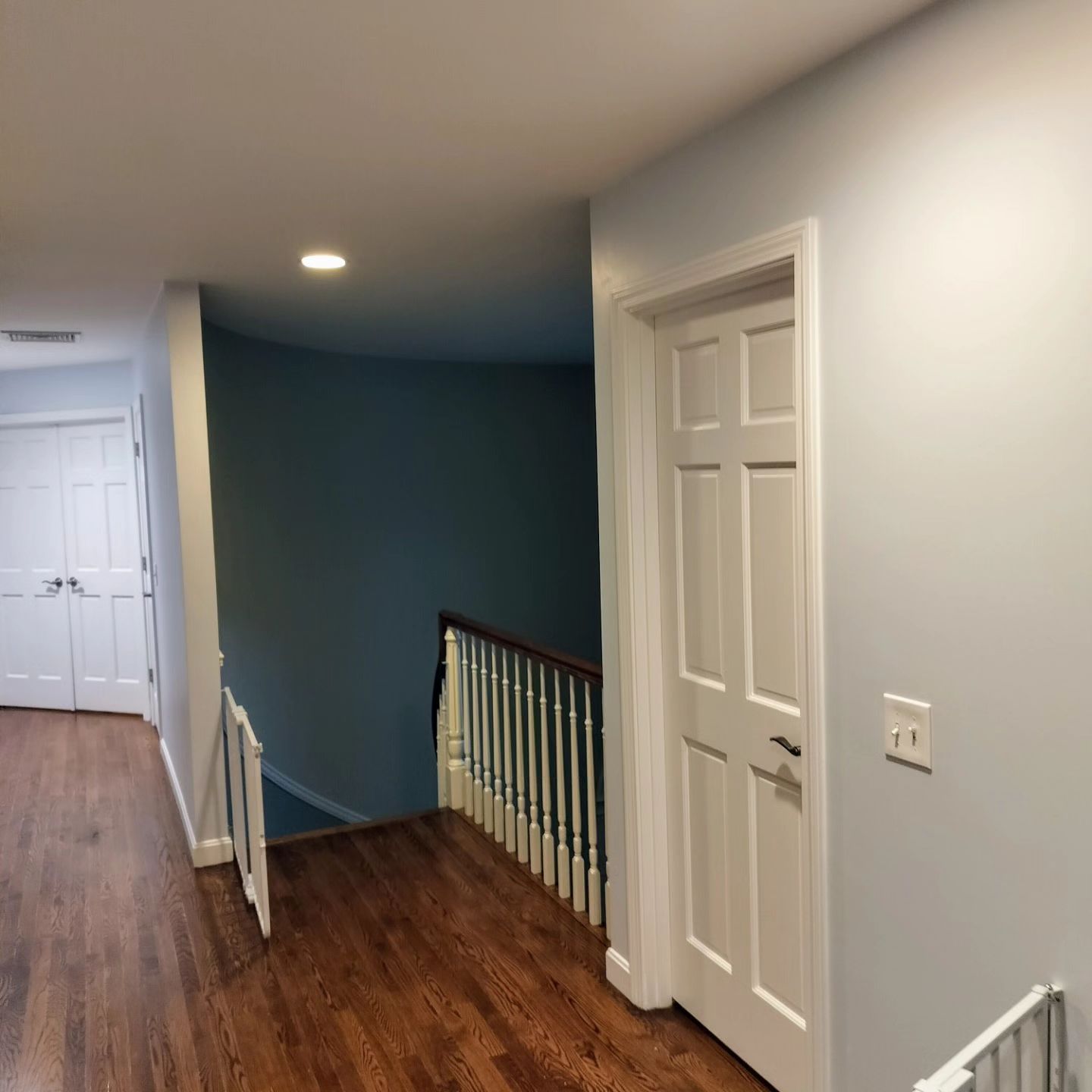 A hallway with stairs and a white door