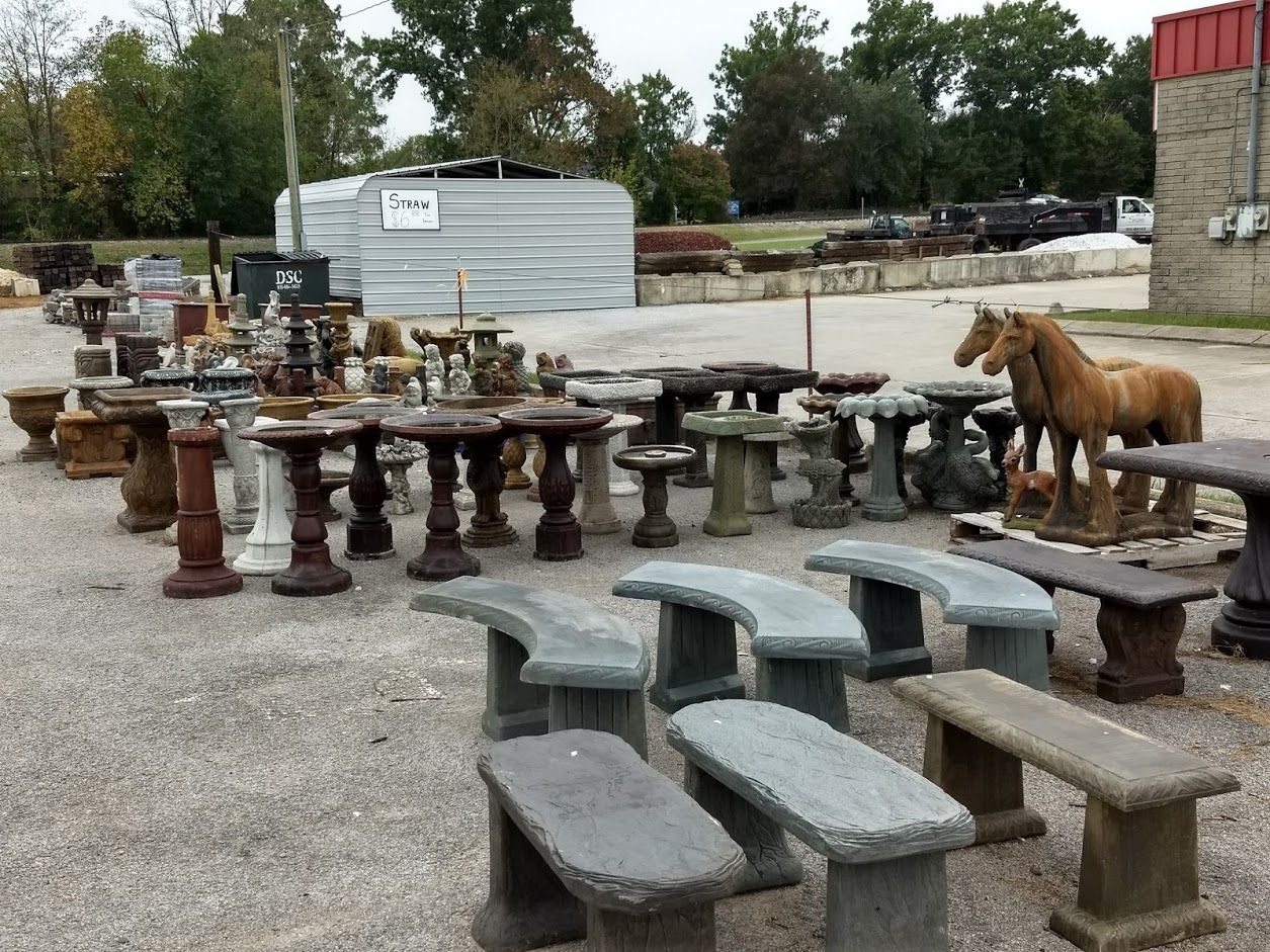 A bunch of stone benches and tables with horse statues in the background