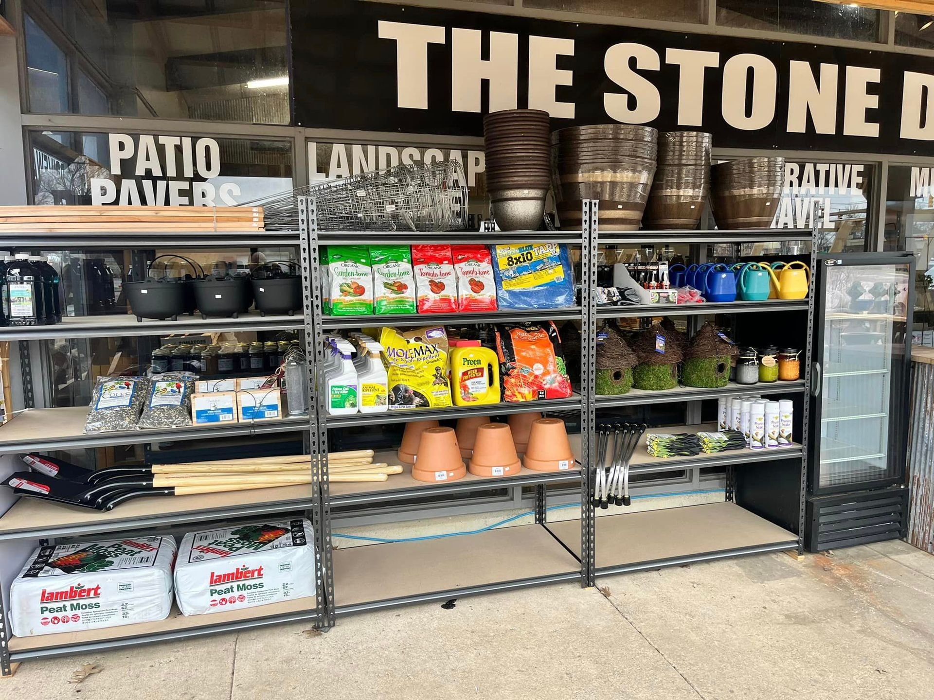A store front with shelves filled with lots of gardening supplies.