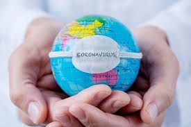 A person is holding a globe with a mask on it.