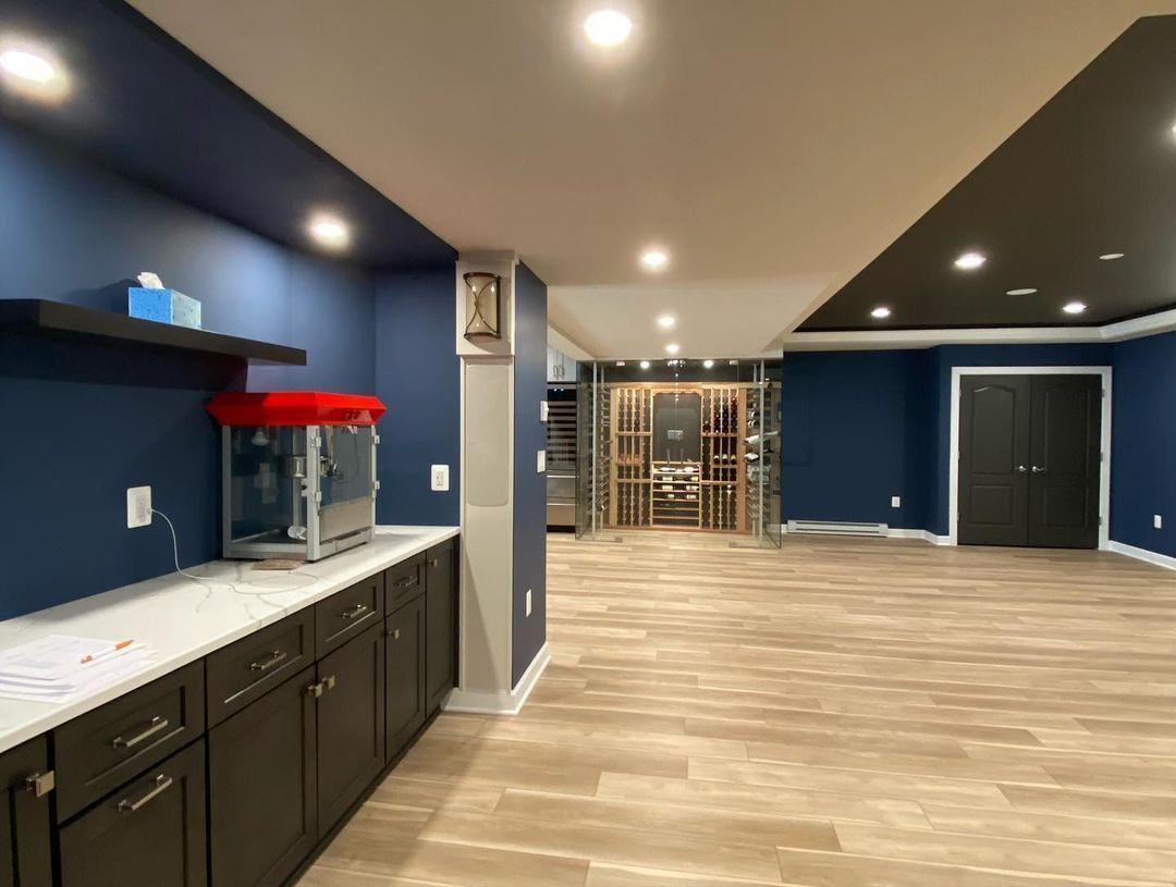 Basement with blue walls, dark cabinets, a popcorn machine, and a wine cellar.
