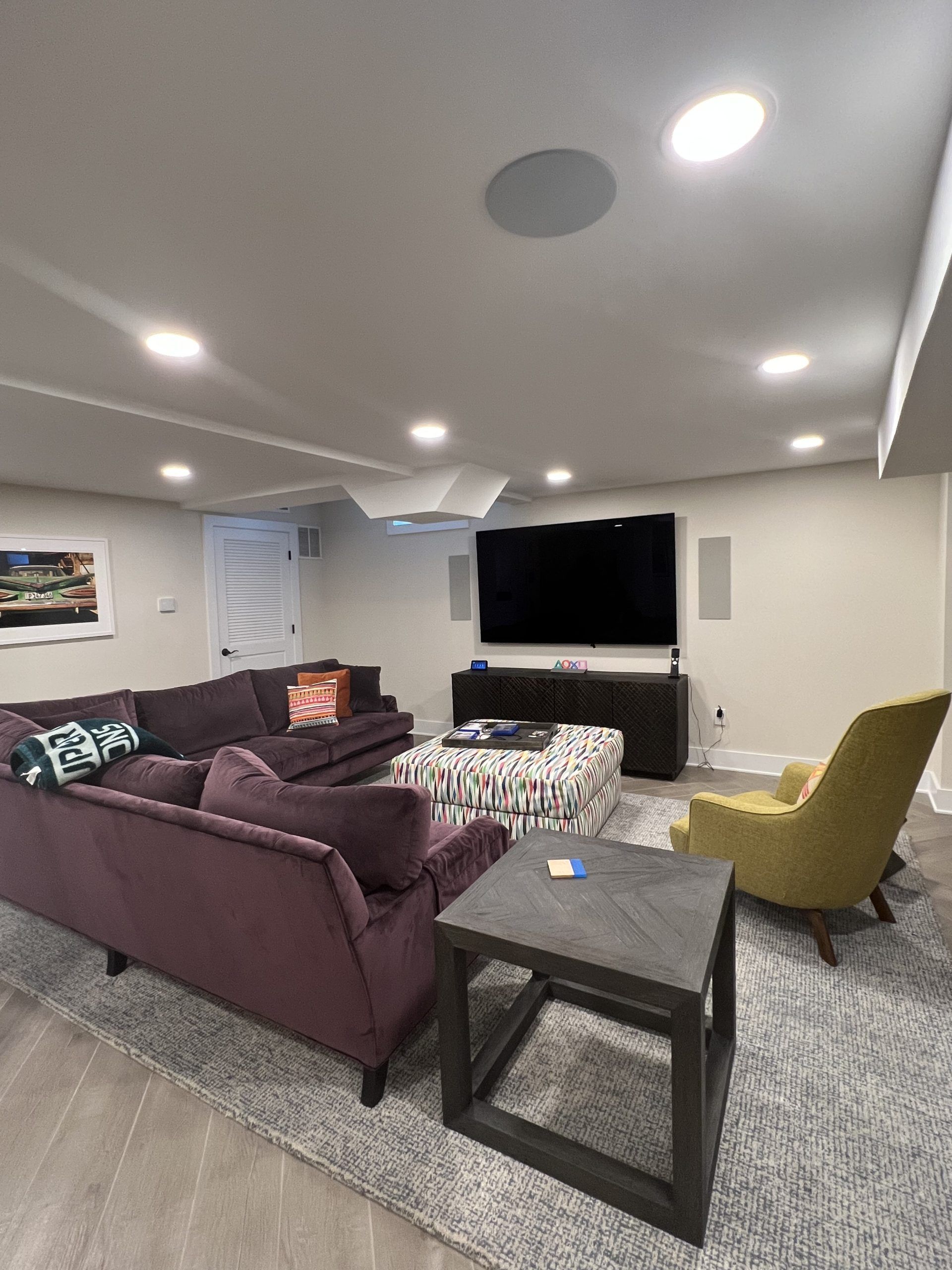 Living room with purple couch, TV, and gray rug.