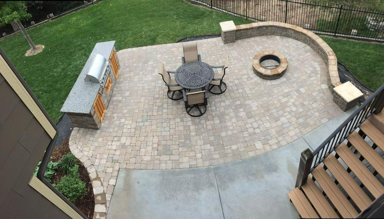 an aerial view of a patio with a table and chairs and a fire pit .