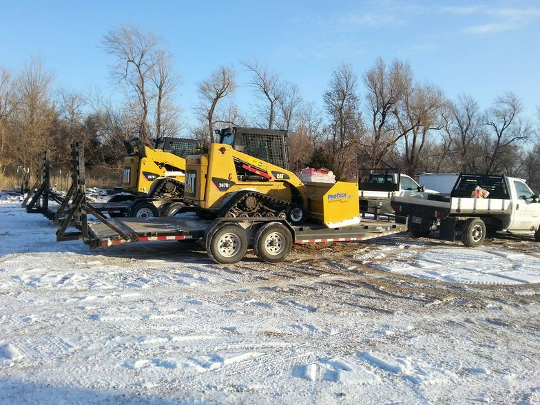a yellow tractor is on a trailer in the snow