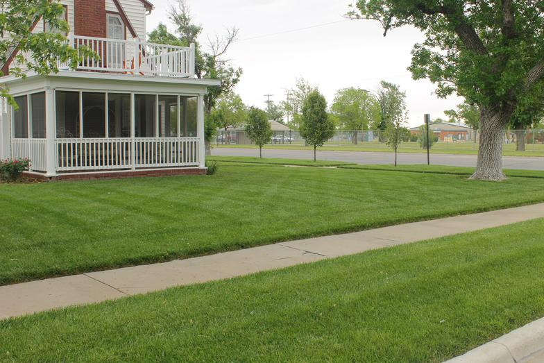 a house with a screened in porch and a lush green lawn