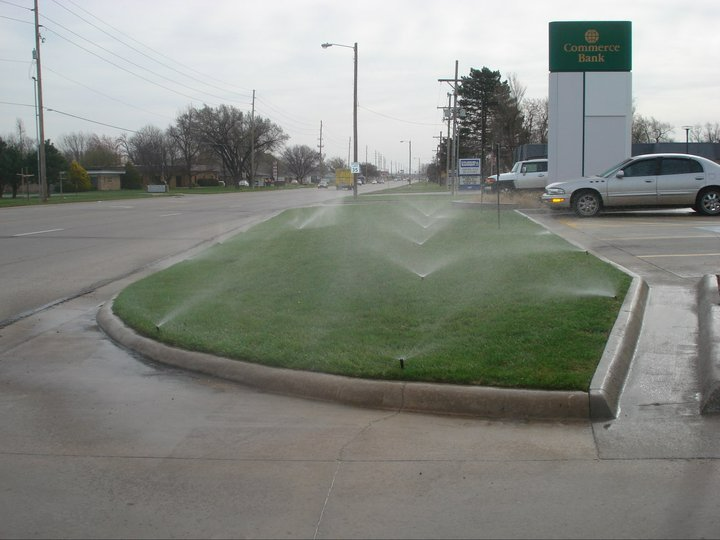 a sprinkler is spraying water on a lush green lawn
