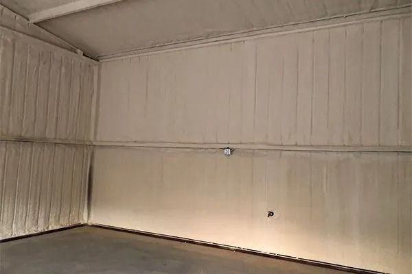 Interior of a metal building with spray foam insulation on walls and ceiling.