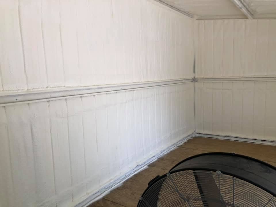 White-painted interior with wood paneling. A black fan sits in the lower right corner.