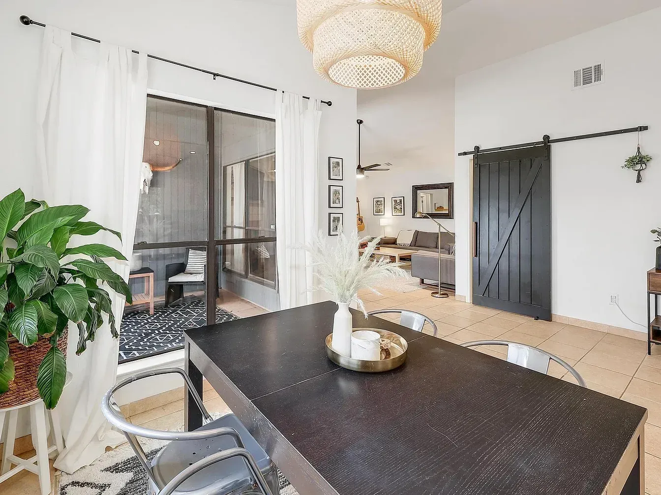 Dining room with dark wood table, metal chairs, and black barn door.