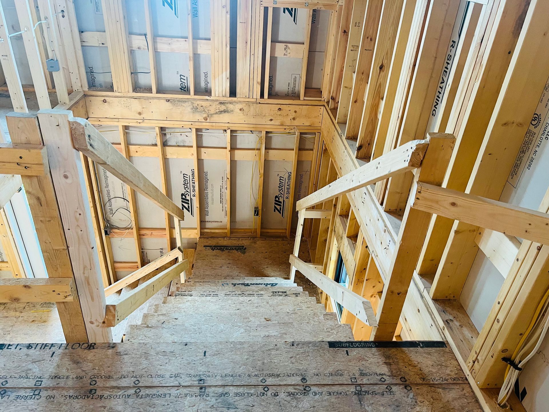 Wooden staircase under construction with framing and handrails.