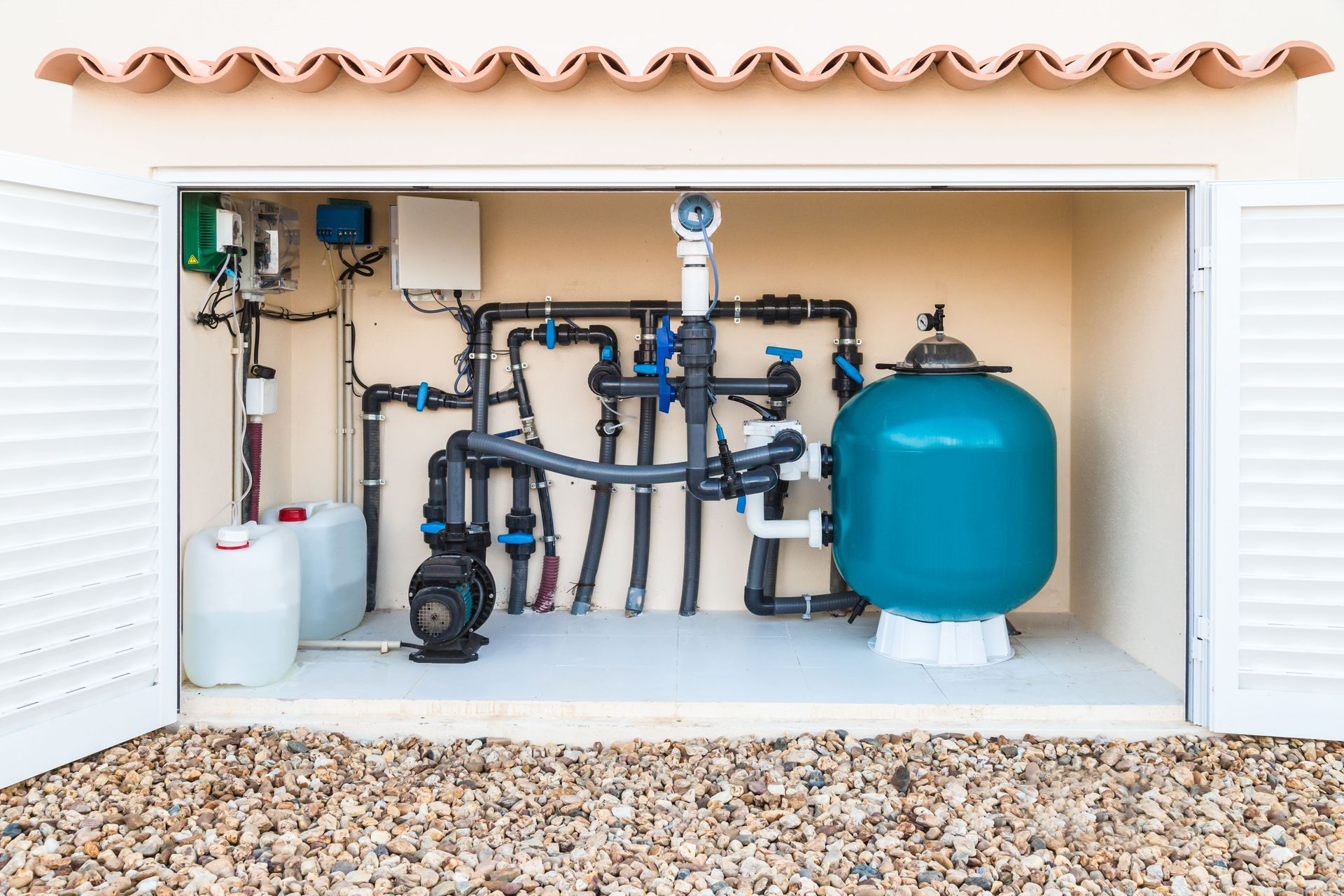 Pool equipment inside a beige shed with open white shutters. Includes a filter, pump, pipes, and chemical containers.