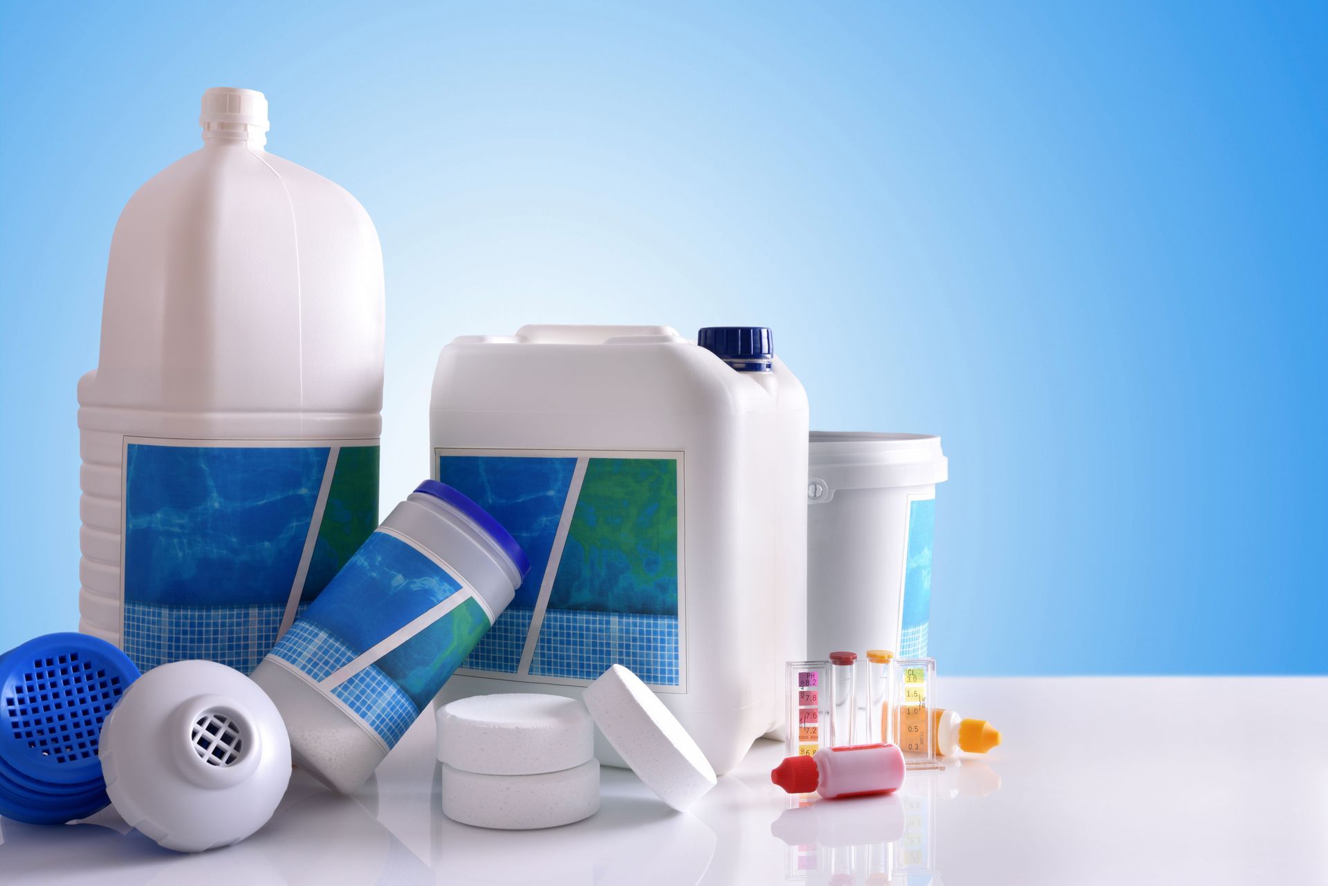 Pool chemicals in white containers and bottles on a white surface, blue gradient background.