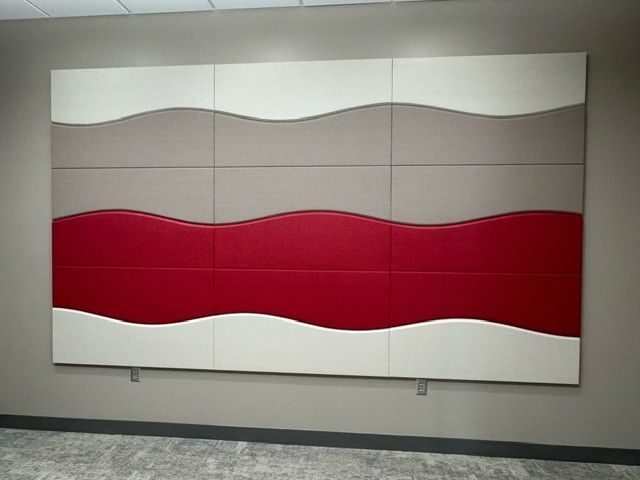 Wall panel with a wavy design in white, gray, and red.