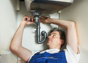 A plumber repairing basin