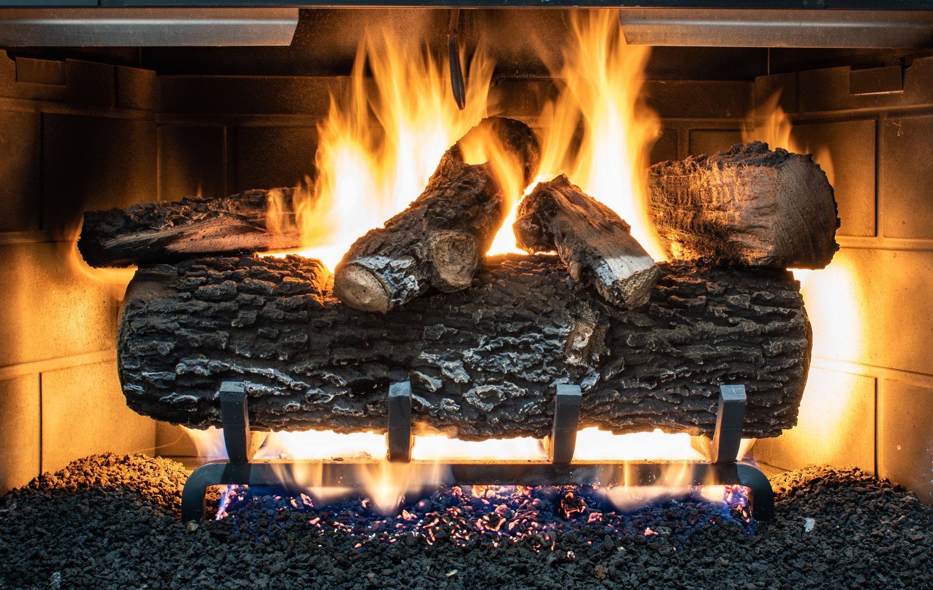Burning logs in a fireplace with bright flames and glowing embers