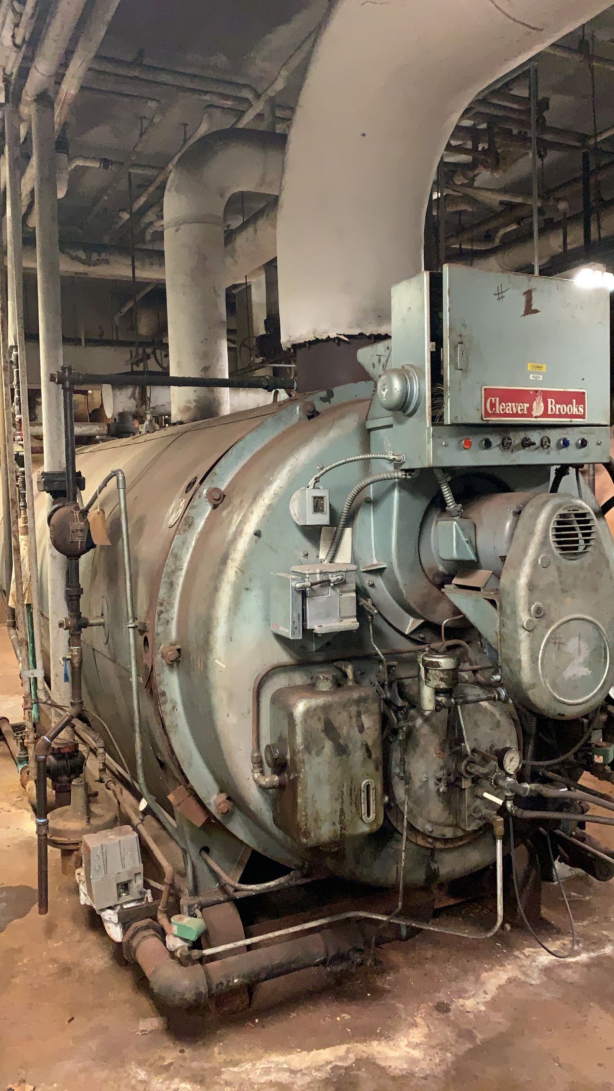A large boiler is sitting in a room in a factory.