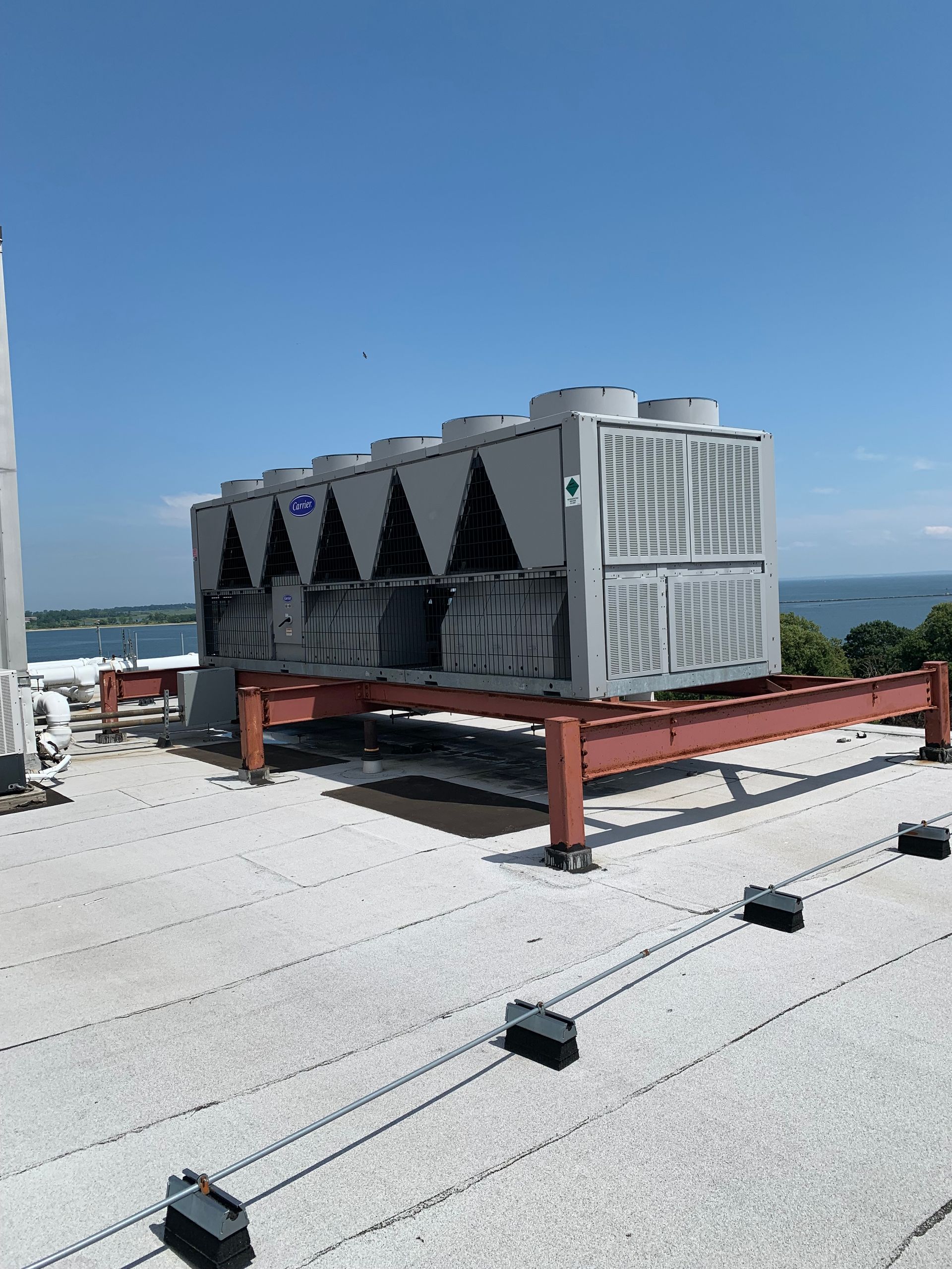 A large air conditioner is sitting on top of a roof.