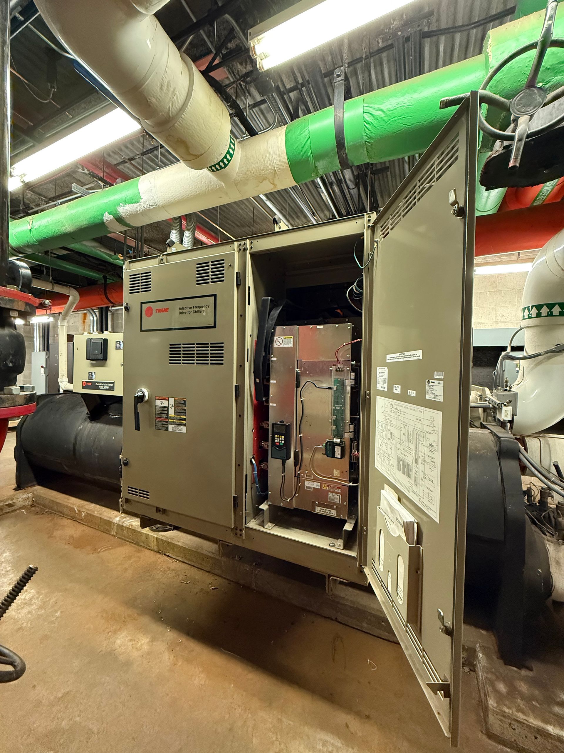 A room with a lot of pipes and a box with the door open