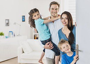 Family standing at front door to invite people at home