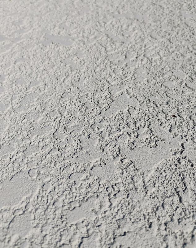 Close-up of rough gray concrete or plaster surface with an uneven texture