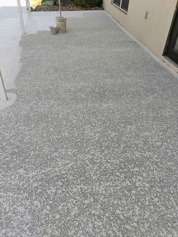 Gravel walkway beside a beige building with a small potted plant near the wall.
