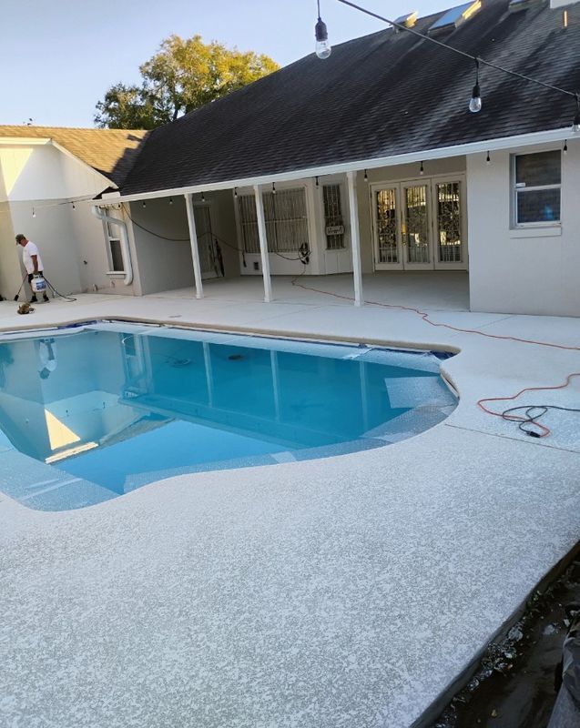 Backyard pool with white deck and a house patio in the background