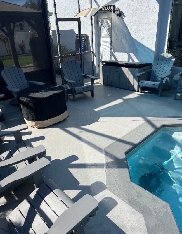 Patio with lounge chairs, a hot tub, and a small blue-tiled pool in bright sunlight