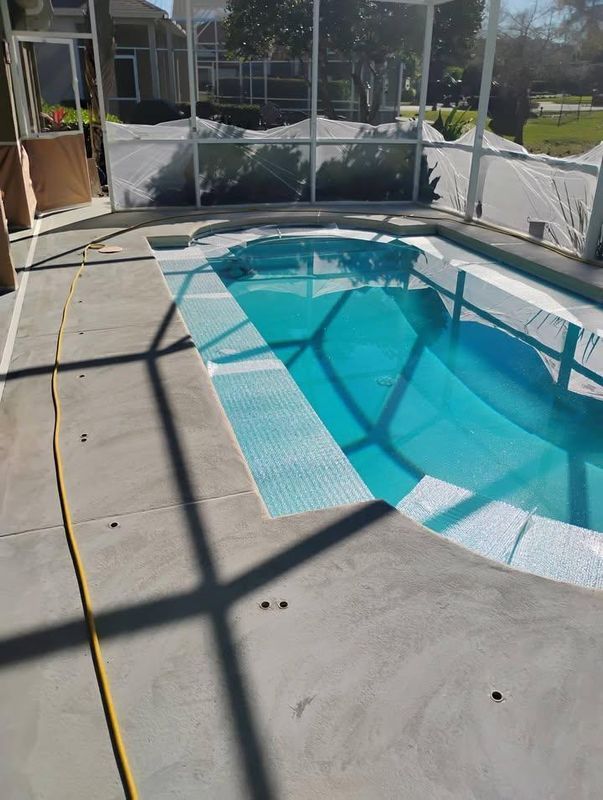 Screened backyard pool with turquoise water and concrete deck in sunlight