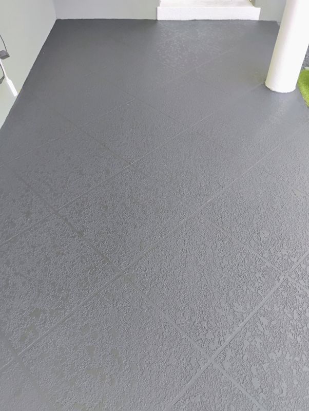 Empty gray carpeted floor in a hallway with white walls and a white column.