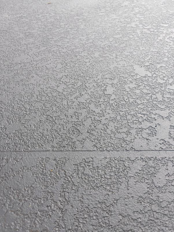 Close-up of a textured gray surface with a horizontal seam across the middle.
