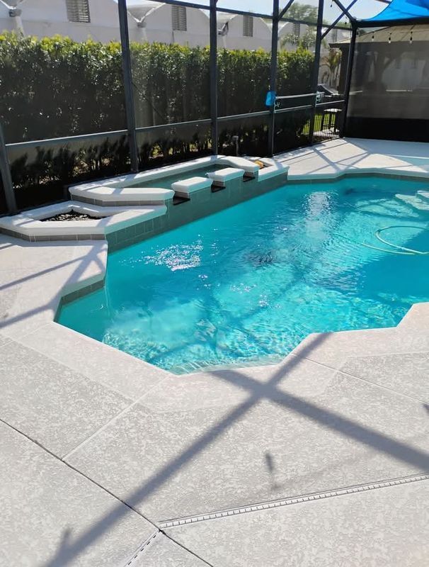 Sunny backyard pool with blue water, white lounge chairs, and a screened enclosure.