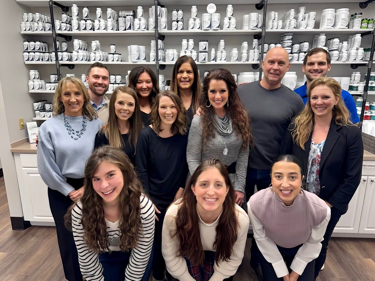 A group of people are posing for a picture in a pharmacy.