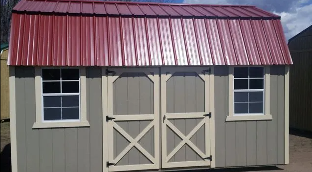 Gray shed with red roof, two windows, and double doors; off-white trim.