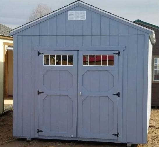 Blue wooden shed with double doors, windows, and a white vent.