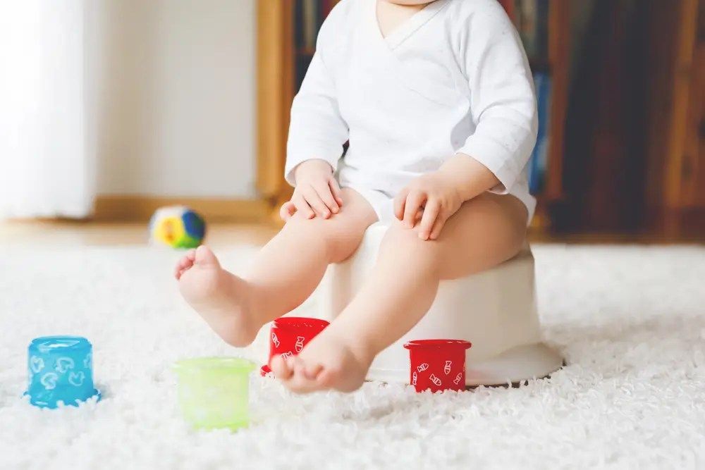 Child seated on a white rug with colorful toy blocks in a bright room