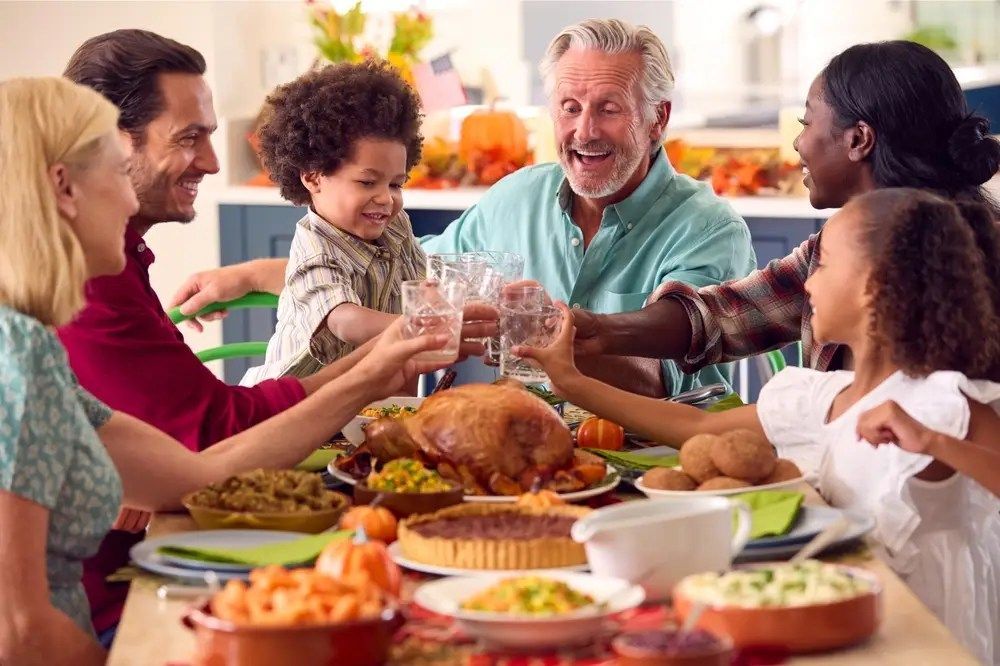 Friends raising glasses around a roasted turkey at a festive dinner table