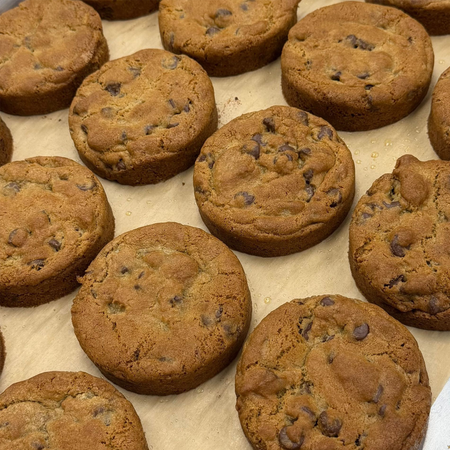 Chocolate chip muffins on parchment paper, freshly baked and golden brown.