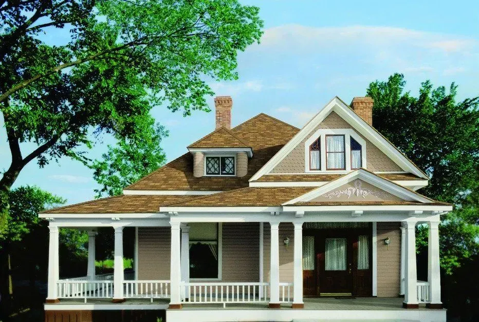 A house with a brown roof and a large porch