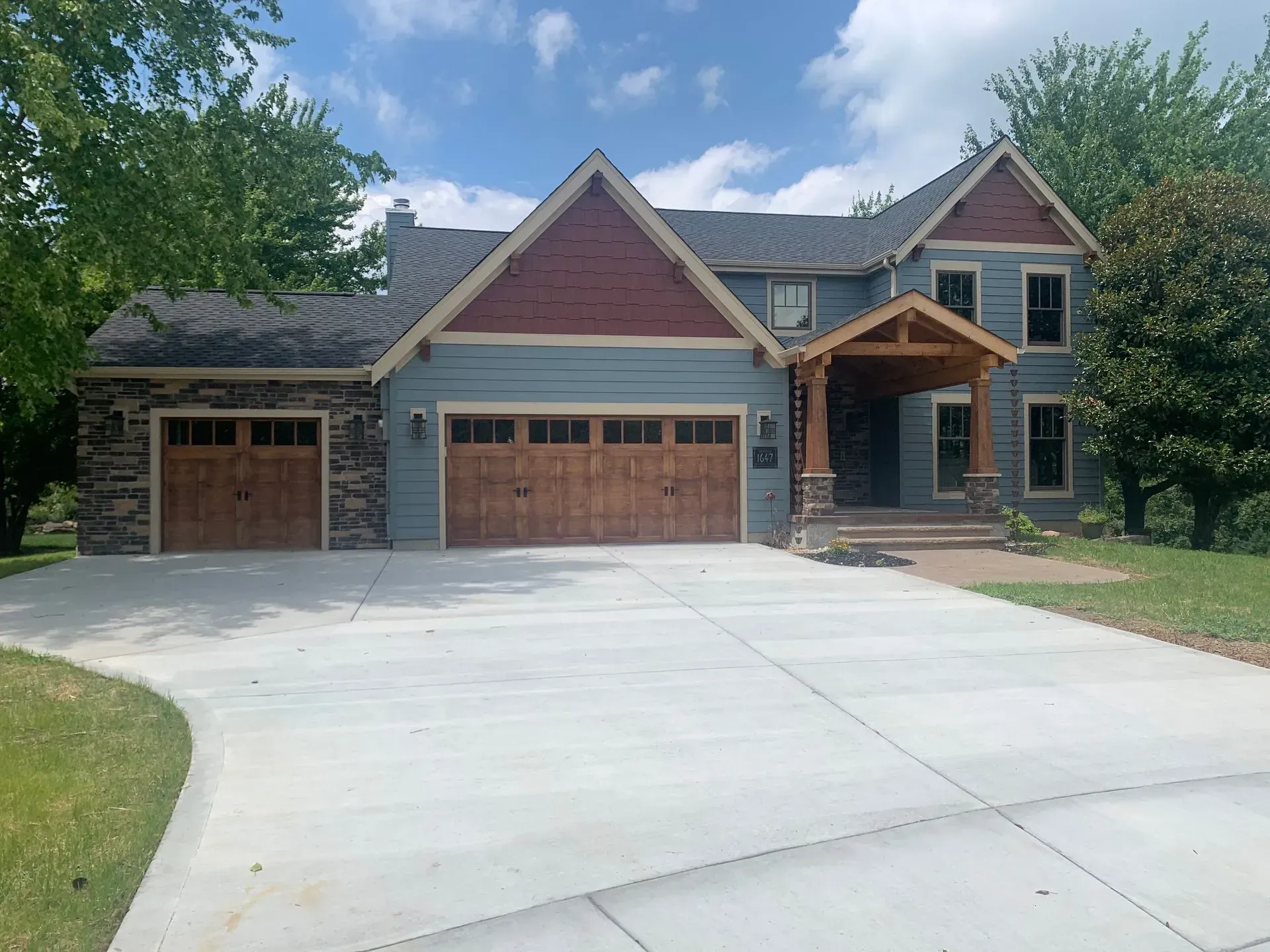 A large house with two garage doors and a concrete driveway