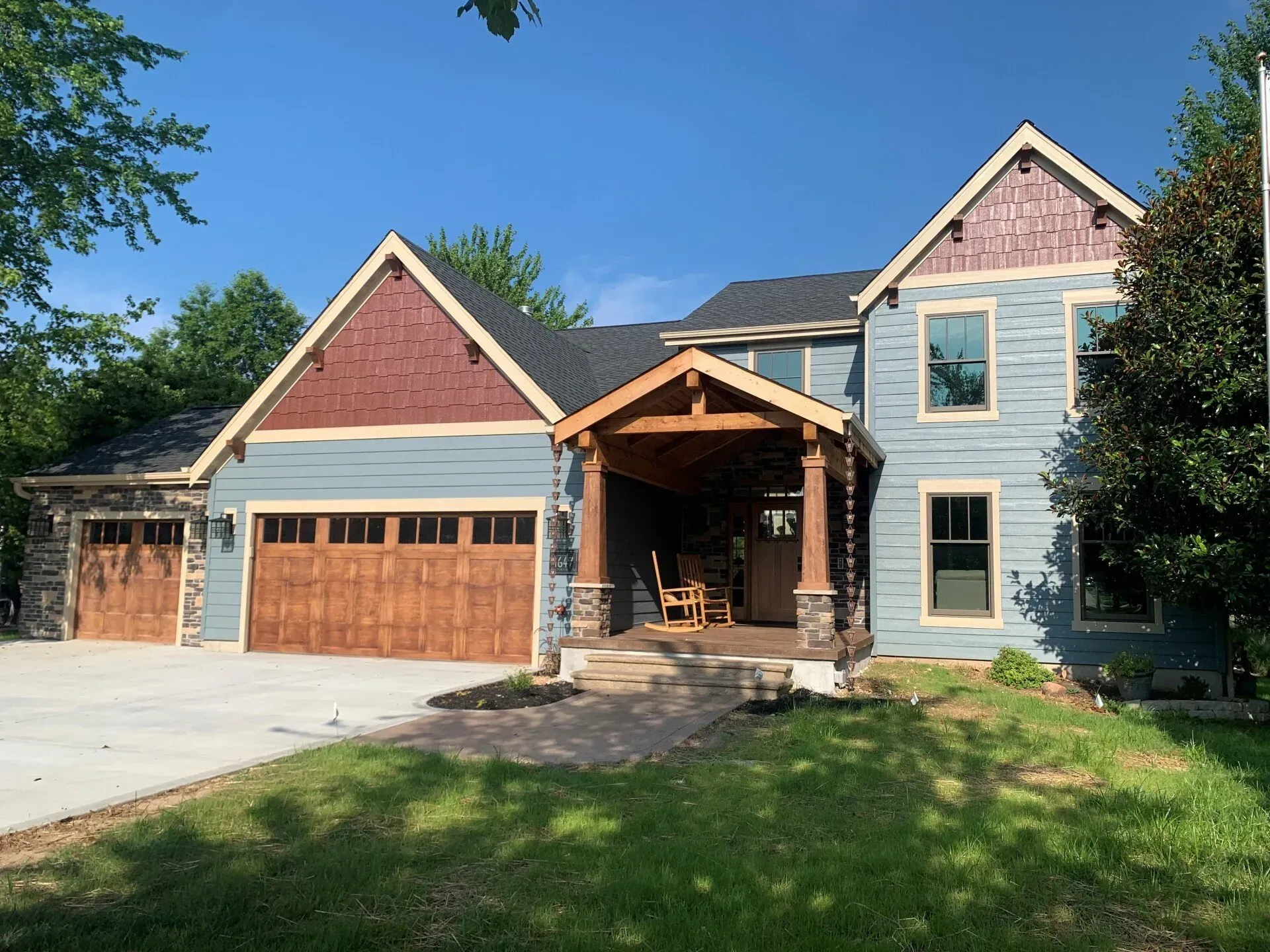 A large house with two garage doors and a porch.
