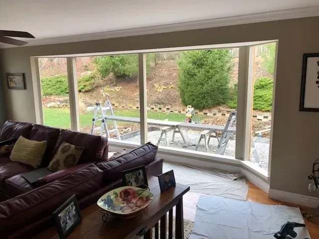 A living room with a purple couch and a large window