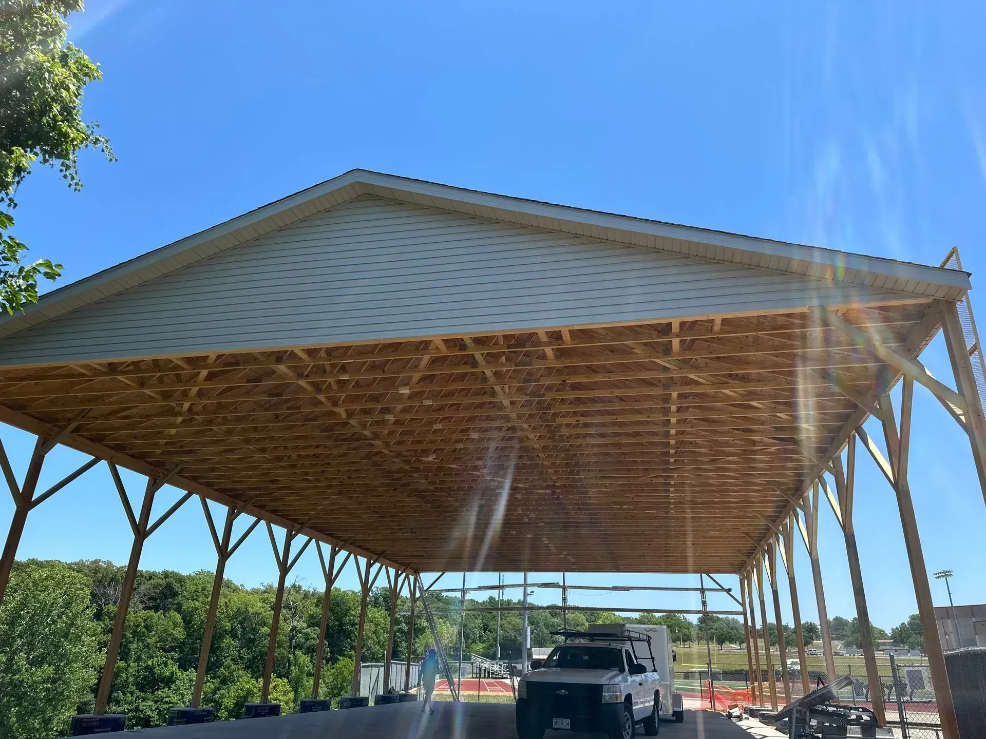 A truck is parked under a large wooden structure.