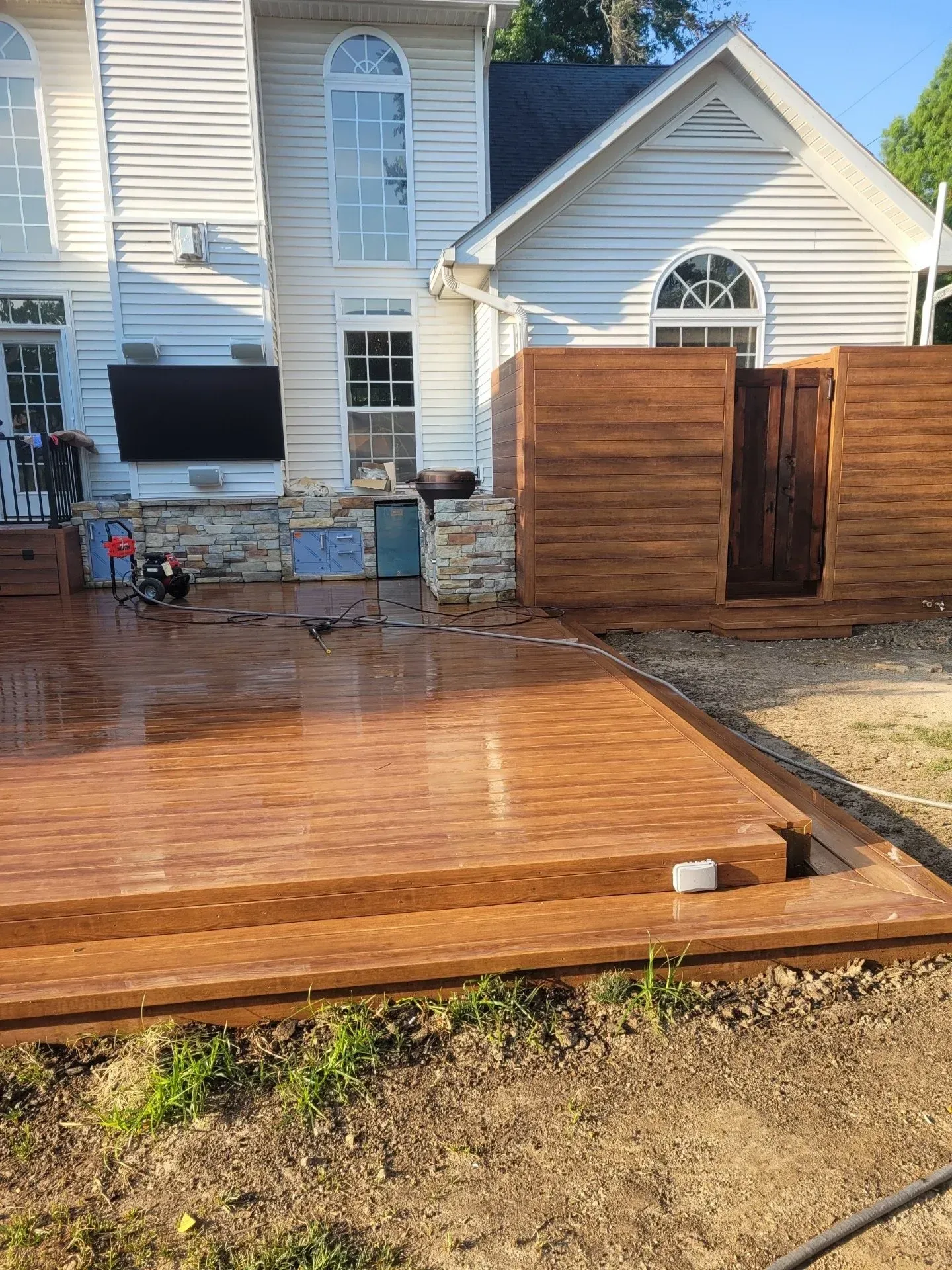 A large white house with a wooden deck in front of it.