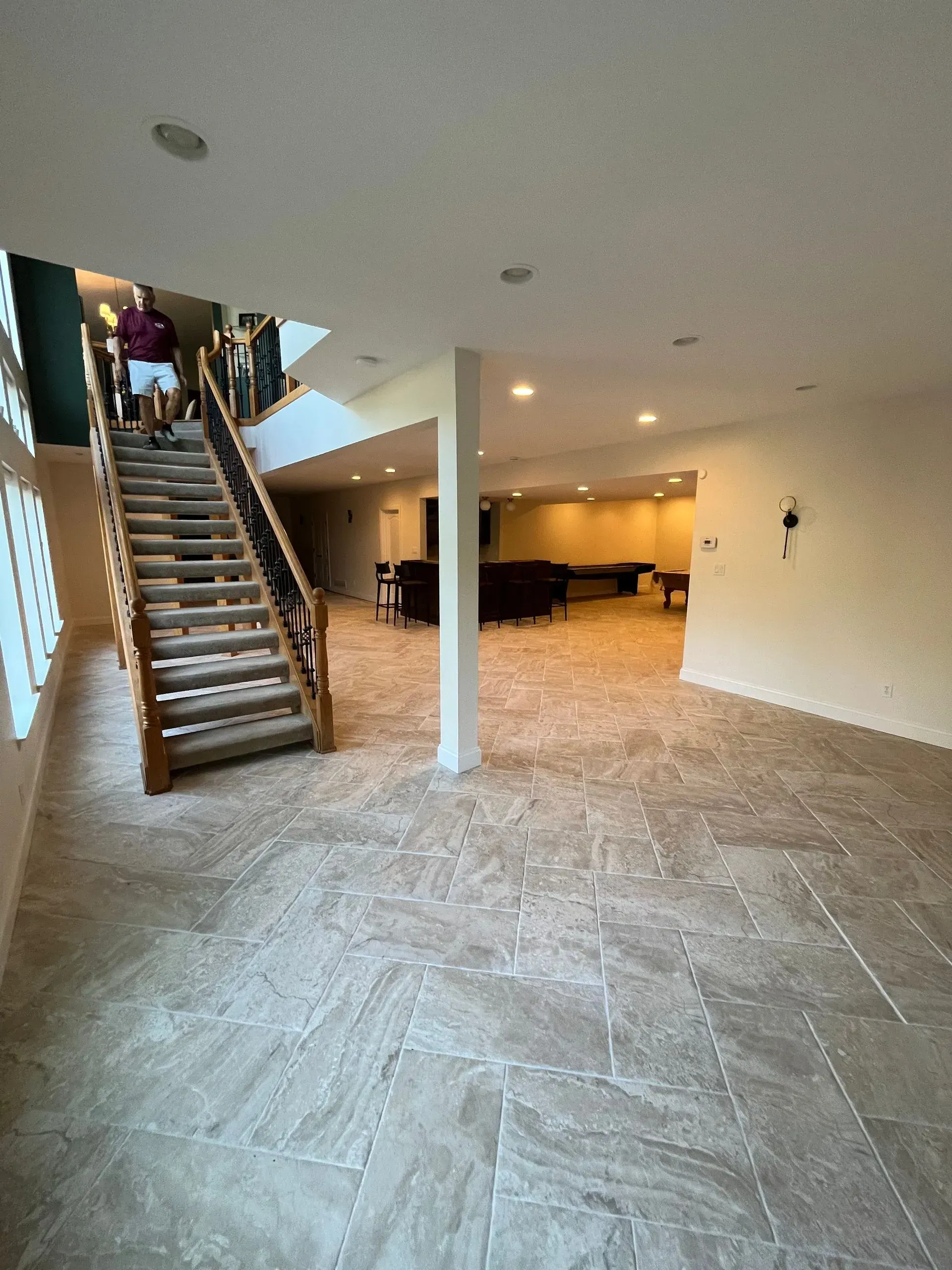 A man is walking up a set of stairs in a basement.