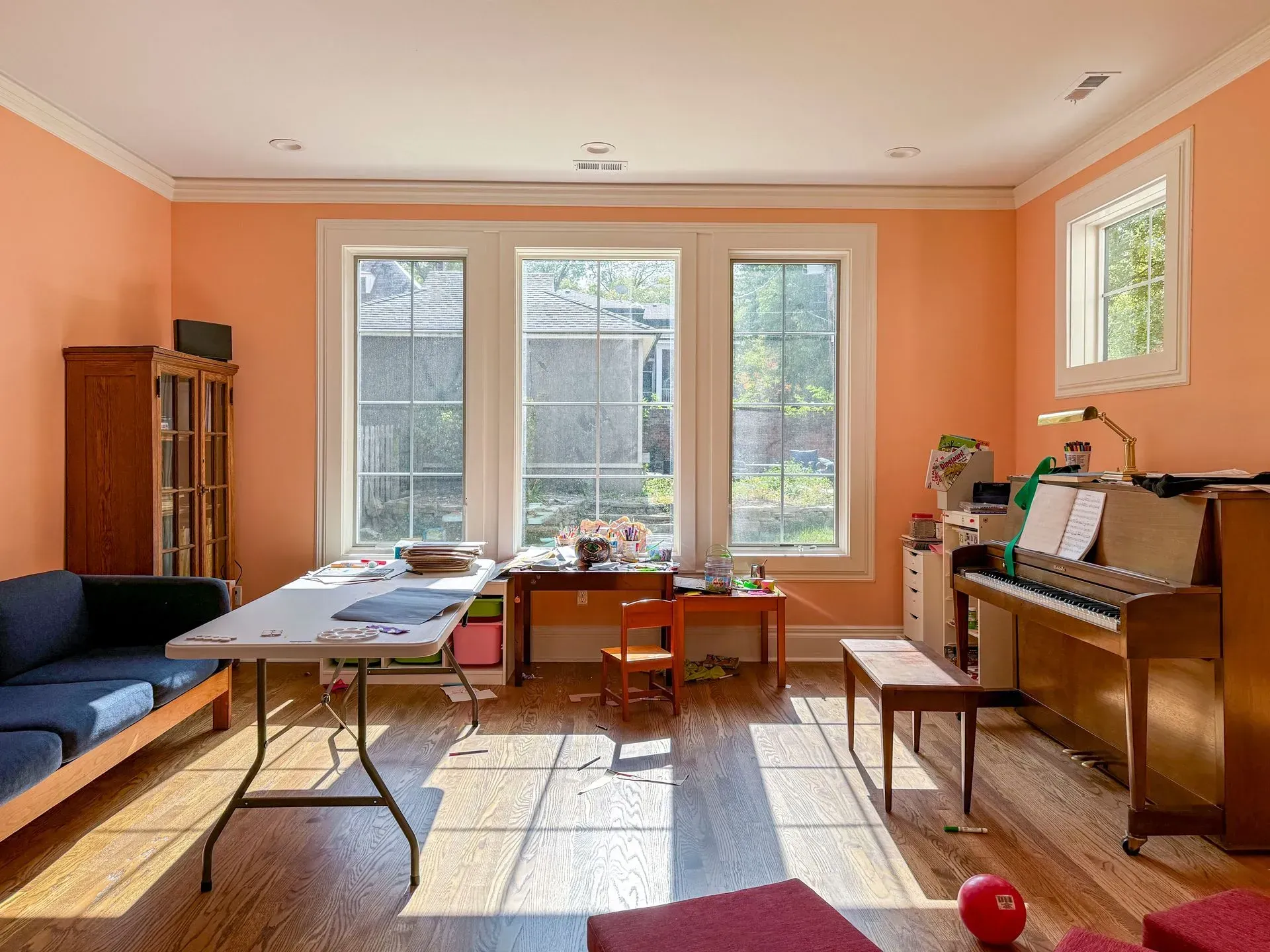 A living room with a table and a piano in it