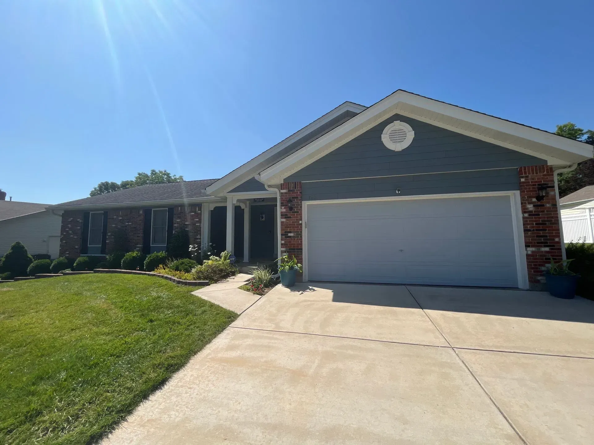 A house with a large garage and a driveway in front of it.