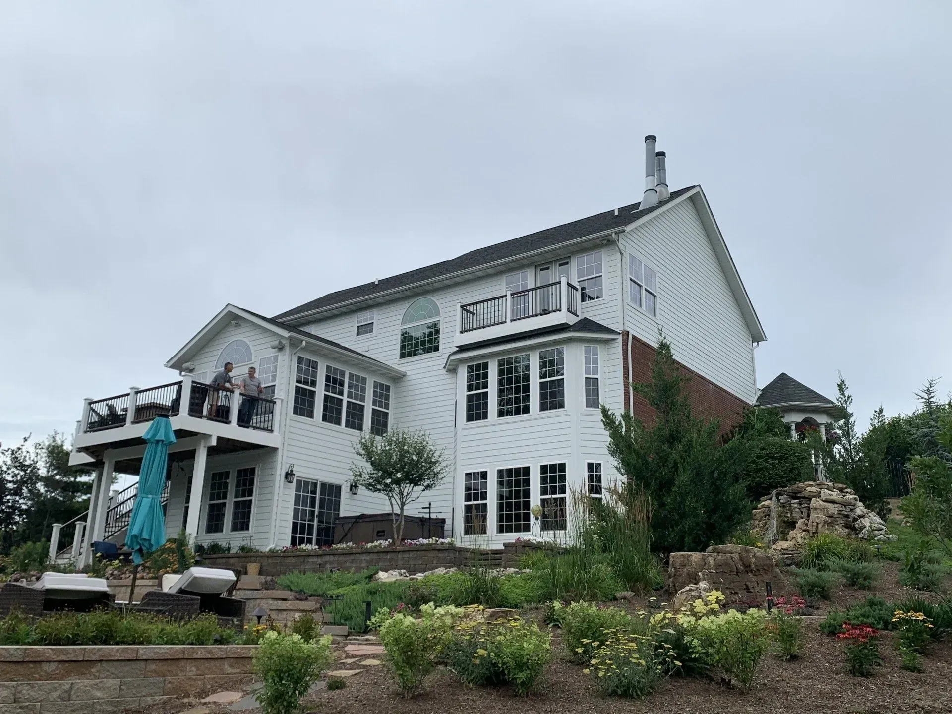 A large white house with a lot of windows is sitting on top of a hill.